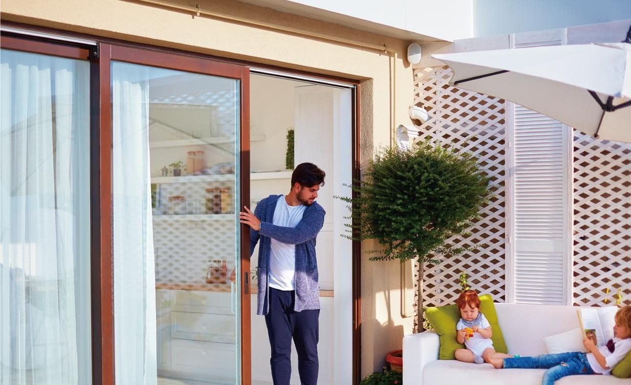 Wood-finish lift and slide patio door opening onto a sunny deck